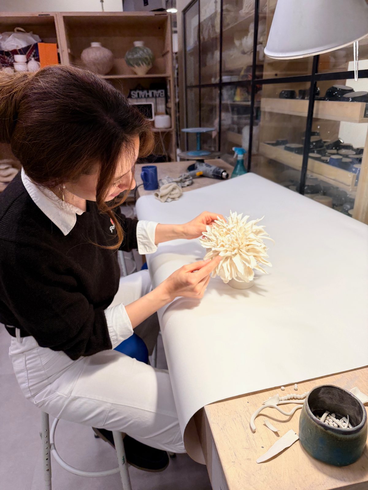 Assembling a porcelain flower head in the studio